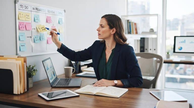 Pessoa dona de pequena empresa analisando lista de tarefas em caderno sobre mesa de trabalho